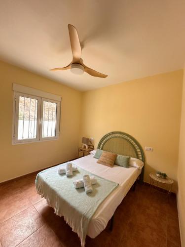 a bedroom with a bed with a ceiling fan at Casa Rural El Pomelo in Zurgena