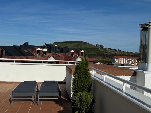 a balcony with two chairs on top of a building at Apartamentos Olga Cantabria 2 in Polanco