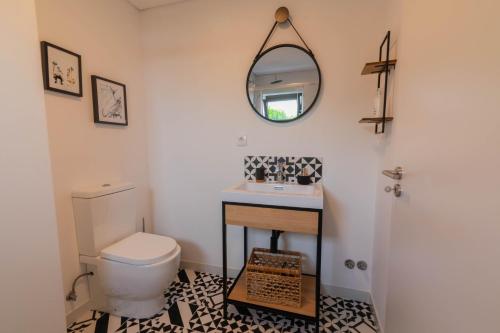 une salle de bain avec toilettes, lavabo et miroir dans l'établissement 7Min to Uni Sé-Velha - AC - Work Desk - 300MBs WiFi - Suite 5, à Coimbra