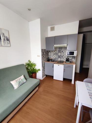 un salon avec un canapé et une cuisine dans l'établissement Le petit oasis dans maison niçoise calme proche mer, à Nice