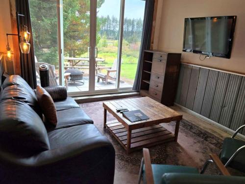 MervilleTiny house & Sauna on Lakefront Farm Oasis的带沙发和咖啡桌的客厅