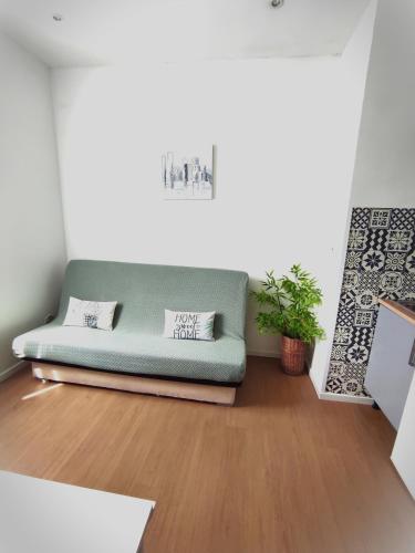 - un canapé dans le salon doté de parquet dans l'établissement Le petit oasis dans maison niçoise calme proche mer, à Nice