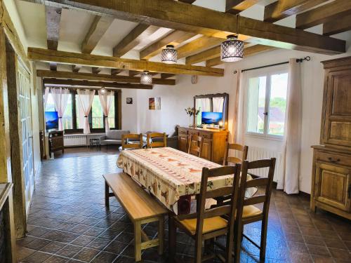 une salle à manger avec une table et des chaises dans une pièce dans l'établissement Cocon familial verdoyant - Famille Only - Fête interdite, à Montreuil-aux-Lions