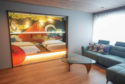 a living room with a bed and a table and a couch at 大町BAY高田屋Omachi BAY Takadaya in Hakodate