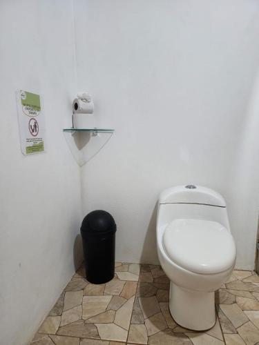 a bathroom with a toilet and a trash can at Casa THIREMA Tortuguero in Tortuguero