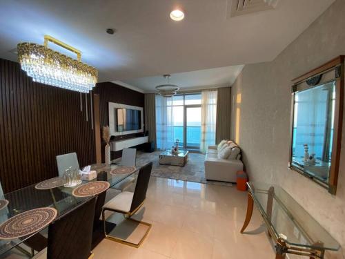a living room with a dining table and a living room at The Sea Facing Apartment in Ajman