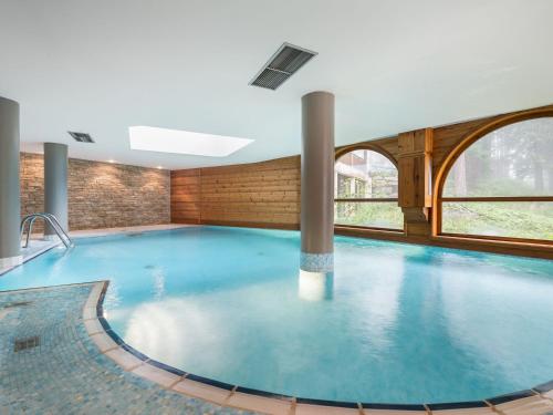 une grande piscine dans un immeuble dans l'établissement Courchevel 1850 - Appartement skis aux pieds avec spa, cheminée et piscine, 3 chambres - FR-1-564-115, à Courchevel