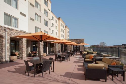 an outdoor patio with tables and chairs and umbrellas at Courtyard Grand Junction in Grand Junction