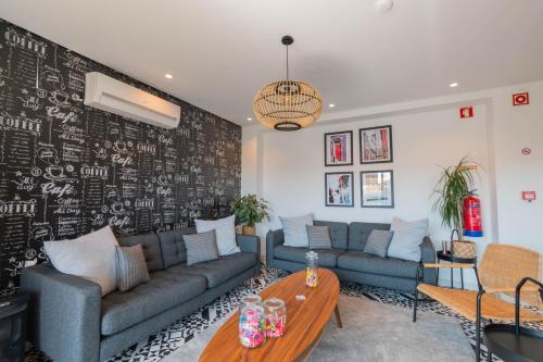a living room with a couch and a table at 7Min to Uni Sé-Velha - AC - Work Desk - 300MBs WiFi - Suite 3 in Coimbra