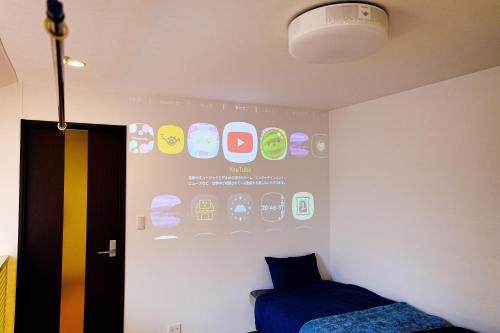 a room with a wall with a screen with iphones at LOISIR Kunitachi in Kunitachi