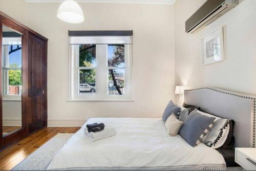 a bedroom with a large white bed with two windows at Charming! 3 Bed Garden by Beach in Largs