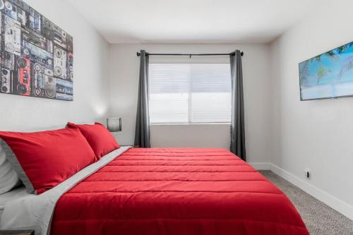 a red bed in a bedroom with a window at 5Mins to Fremont 10Mins to Strip! Sleeps 8! in Las Vegas