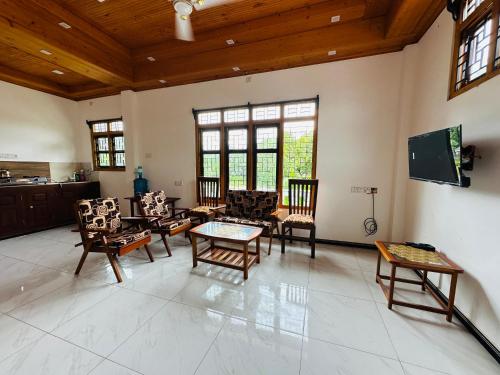 a large living room with chairs and a table at Avanthika Holiday INN in Jaffna