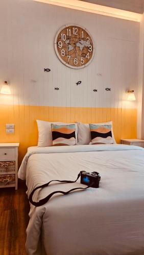 a camera sitting on a bed with a clock on the wall at The Pool House Pattaya No.8 in Pattaya South
