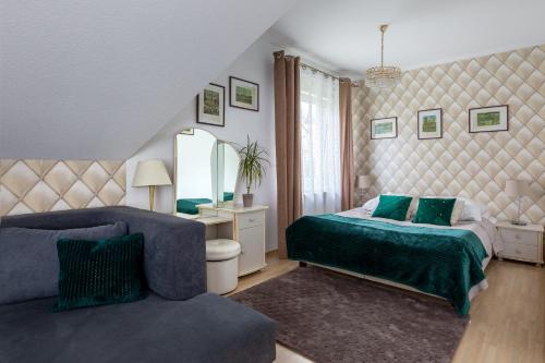 a bedroom with a bed and a chair and a mirror at APARTAMENTY VILLA PIGMALION - sauna, jacuzzi, parking, ogród in Kudowa-Zdrój