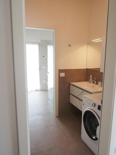 a laundry room with a washer and a sink at Casa Del Gatto Relax e Natura tra le Dolomiti in Cles