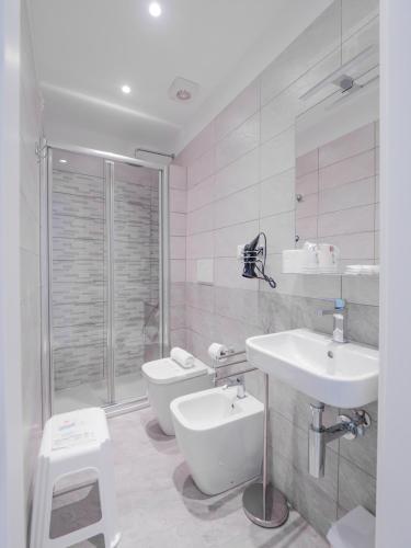 a white bathroom with a sink and a toilet at Hotel La Bussola in Finale Ligure