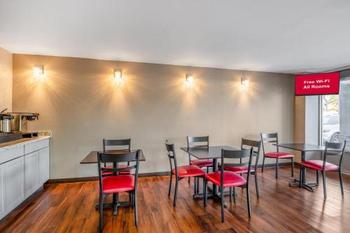 a dining room with tables and red chairs at Red Roof Inn Richmond - Airport Sandston in Sandston