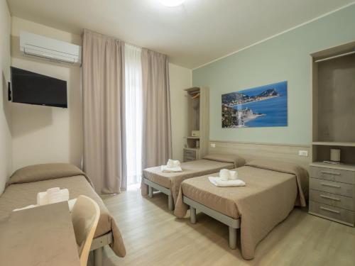a hotel room with two beds and a television at Hotel La Bussola in Finale Ligure
