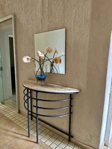 a table with a blue vase with flowers on it at Palace Hotel in Itajubá