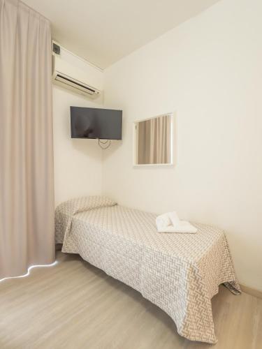 a bedroom with a bed and a tv on the wall at Hotel La Bussola in Finale Ligure
