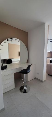 a desk with a mirror and a chair in a room at Deluxe Rezidencija Bijeljina in Bijeljina