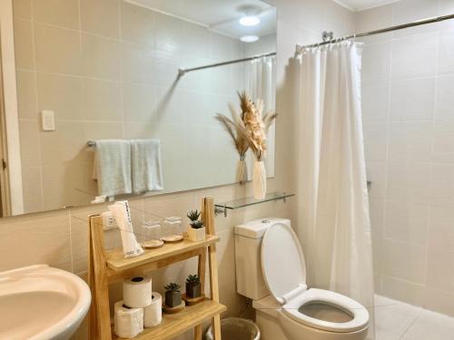 a bathroom with a toilet and a sink and a shower at Studio in Azure North Pampanga in San Fernando