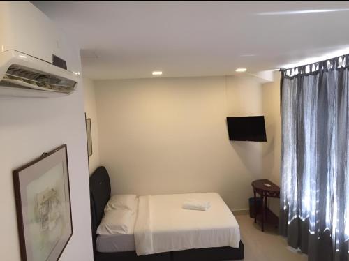 a small room with a bed and a television at FKI INTERNATIONAL HOTEL in Kuala Lumpur