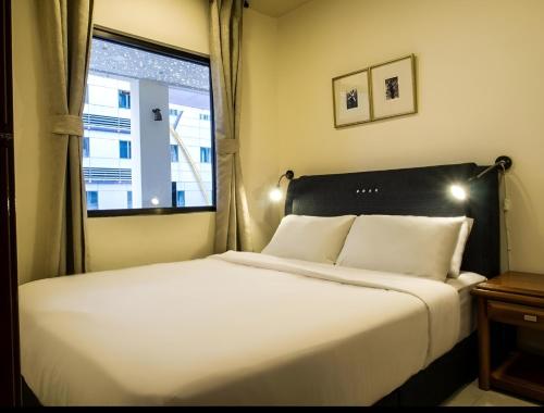 a bedroom with a large white bed with a window at FKI INTERNATIONAL HOTEL in Kuala Lumpur