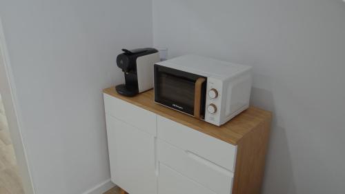 a microwave sitting on top of a wooden shelf at Pensión Casa de Casiano en Esteiro in Muros