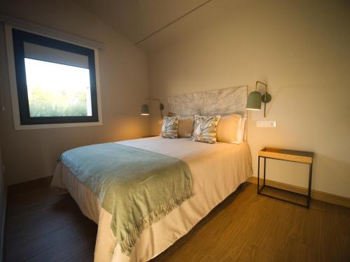 a bedroom with a large bed and a window at Alto da Pousa in Tomiño
