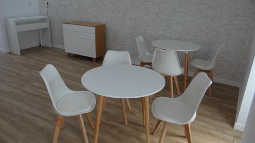 a group of white tables and chairs in a room at Pensión Casa de Casiano en Esteiro in Muros