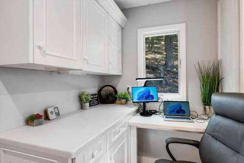 a white kitchen with two laptops on a counter at Mt Views - Sauna - Hot Tub - Adulting - Family Fun in Massanutten