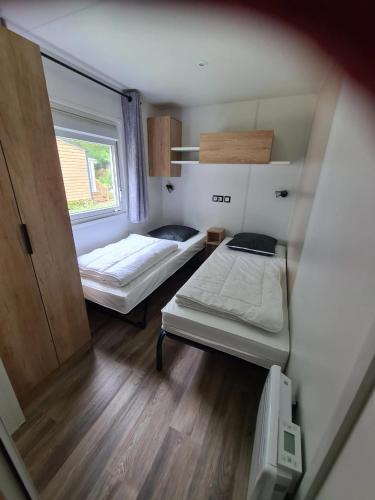 une petite chambre avec deux lits et une fenêtre dans l'établissement Bungalow confortable à Saint-Jean-de-Monts - 45 m², à Saint-Jean-de-Monts