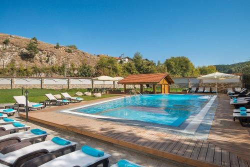 a swimming pool with chairs and a gazebo at Apartment in Hotel Sveti Spas 5 Velingrad in Velingrad