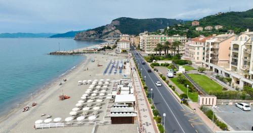 a view of a beach with buildings and the water at Hotel La Bussola in Finale Ligure