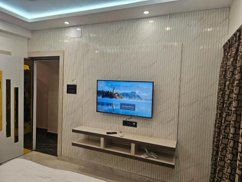 a living room with a tv on a wall at LUXE Lagoon in kolkata