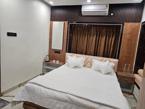 a bedroom with a large bed with white sheets and pillows at LUXE Lagoon in kolkata