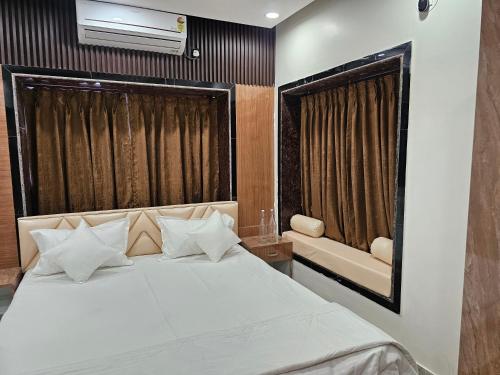 a bedroom with a large white bed with a window at LUXE Lagoon in kolkata