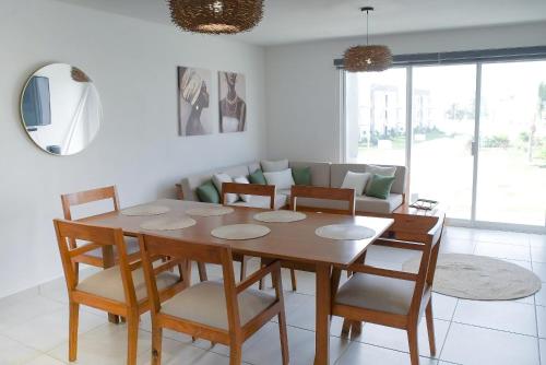 a living room with a wooden table and chairs at Acapulco diamante, club de playa privado, canchas pádel para 8 huéspedes in Acapulco