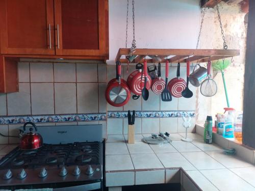 a kitchen with red pots and pans hanging from the wall at Charming Home on La Calzada in Granada