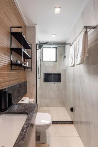 a bathroom with a shower and a toilet and a sink at Flat pé na areia na praia de Porto de Galinhas próximo as piscinas naturais. in Porto De Galinhas