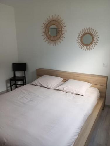 - une chambre avec un lit et deux miroirs sur le mur dans l'établissement Maison 3 chambres 4 lits 6 personnes, à Challans