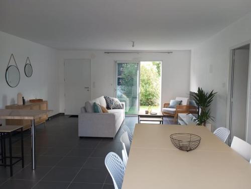 a living room with a table and a couch at Maison 3 chambres 4 lits 6 personnes in Challans