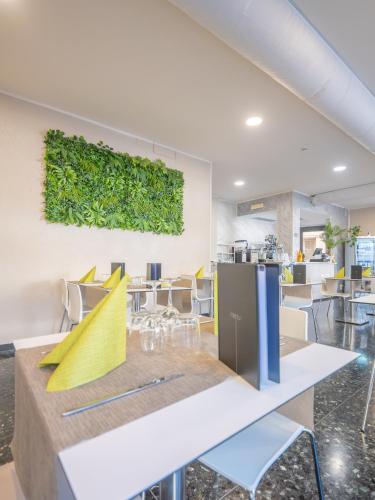 a dining room with a green wall at Hotel La Bussola in Finale Ligure