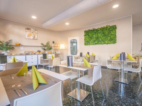 un ristorante con tavoli e sedie con cuscini gialli di Hotel La Bussola a Finale Ligure