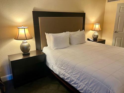 a bedroom with a large bed with two lamps at Jockey Resort Suites Center Strip in Las Vegas