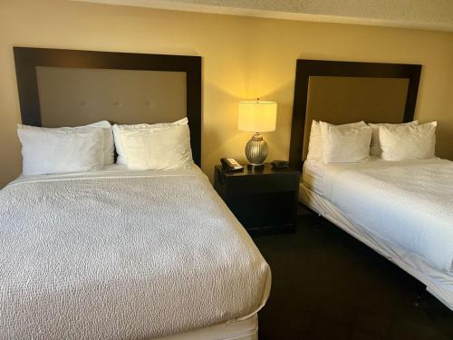 a hotel room with two beds and a lamp at Jockey Resort Suites Center Strip in Las Vegas