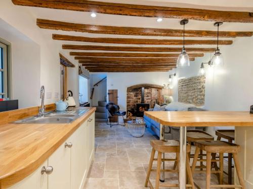 a kitchen and living room with wooden ceilings and a table and chairs at 2 Bed in Holt 78233 in Cley next the Sea