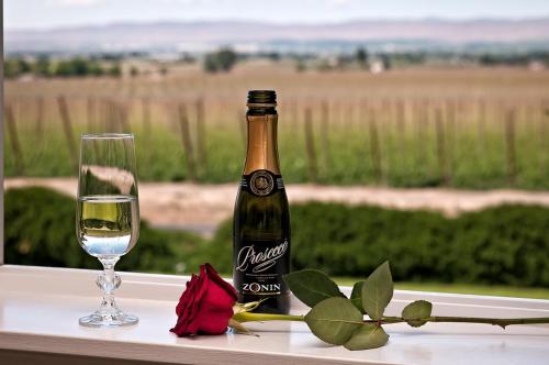 a bottle of wine and a glass on a window sill at Cozy Rose Inn in Prosser